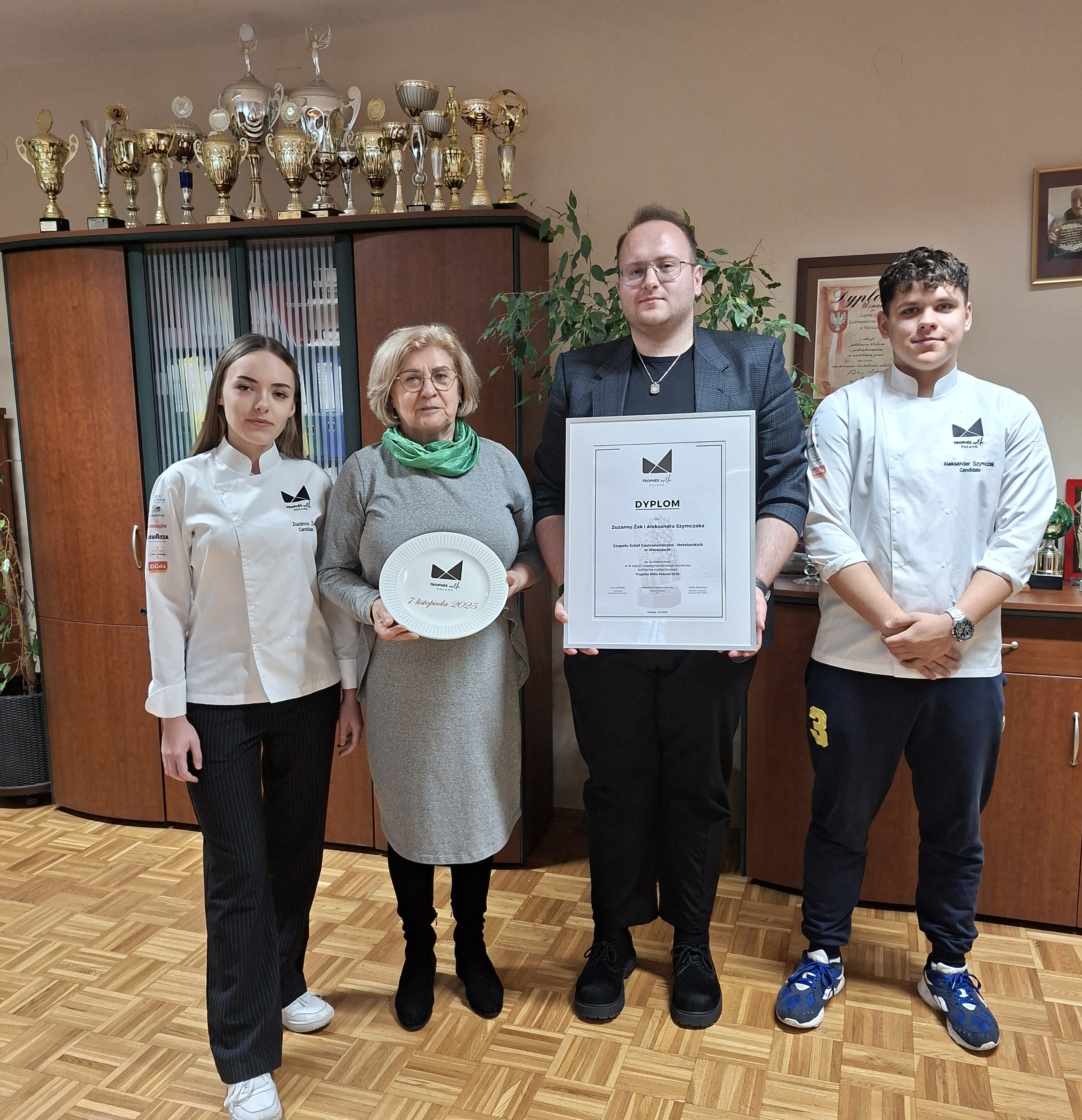 dyrektor szkoły z nauczycielem i uczestnikami konkursu