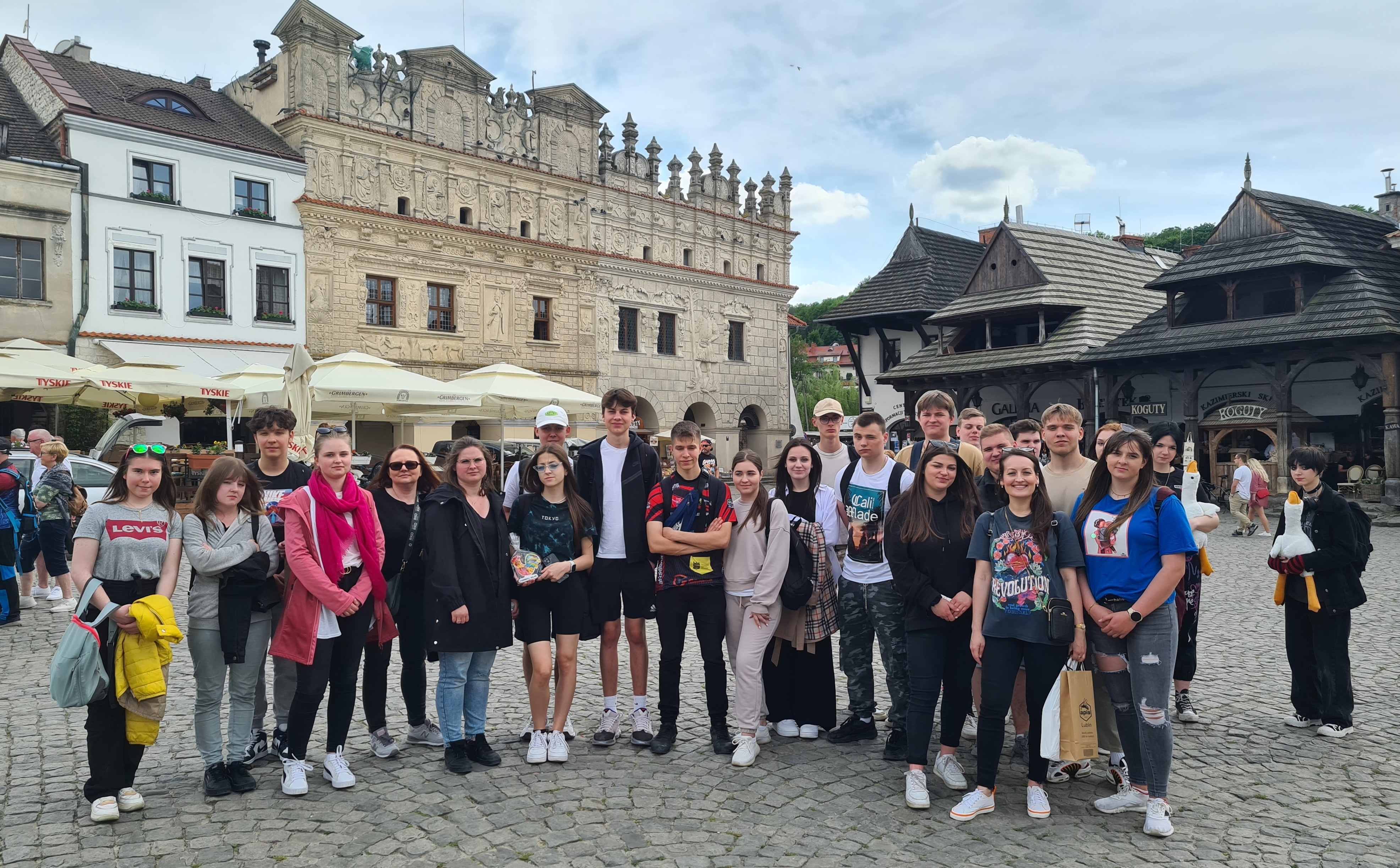 Zdjęcie nr 1 przedstawia uczniów zwiedzających  rynek główny Kazimierza Dolnego